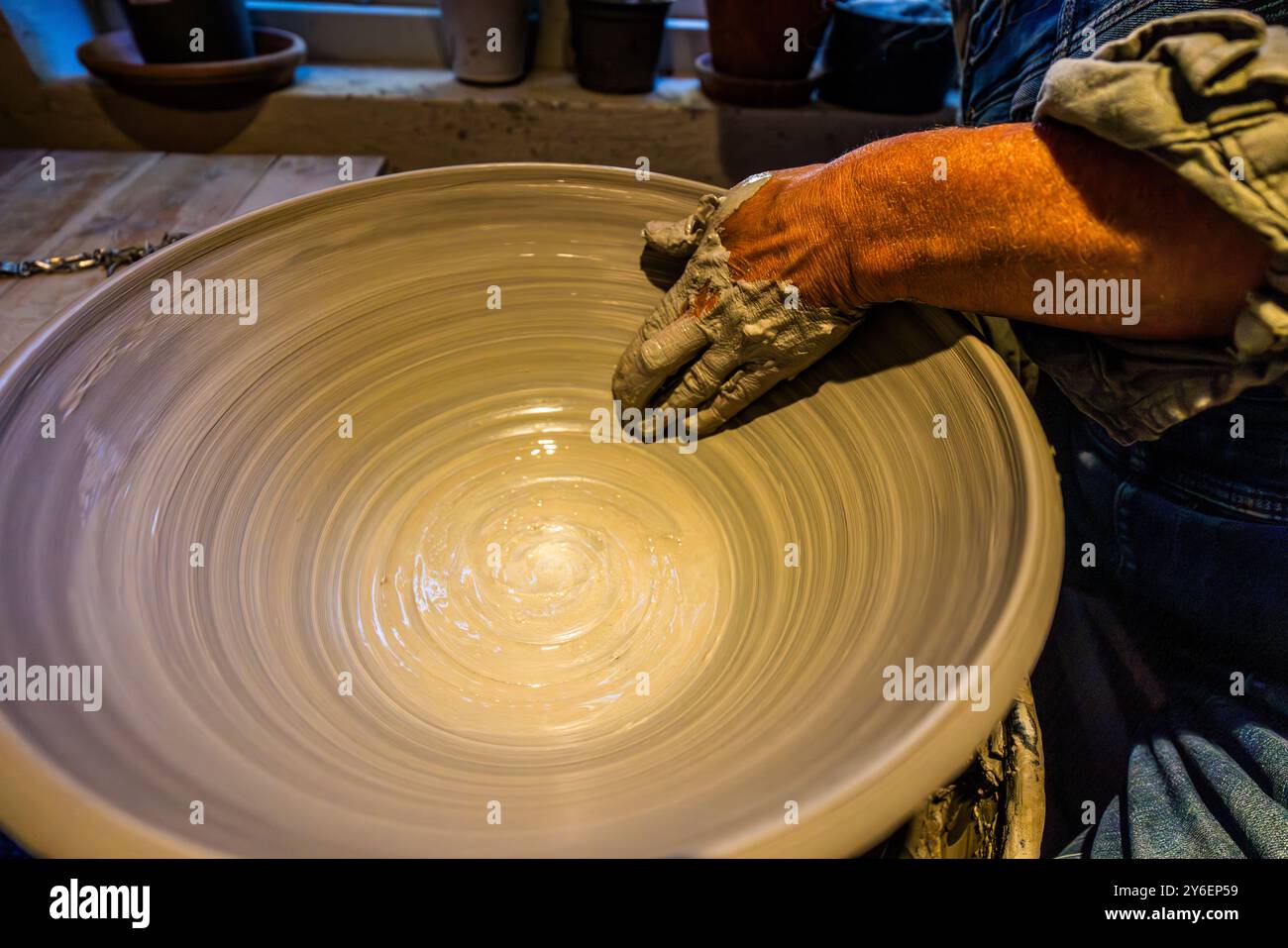 Lisa Wohlfahrt at the potter's wheel in her studio in Mölle. Each piece goes through up to 15 processing steps before it is finished and is unique, Mölle Krukmakeri. Mölle Krukmakeri has grown from a pure pottery business into a trendy shop and restaurant. Mölle hamnallé, Höganäs kommun, Skåne, Sweden Stock Photo