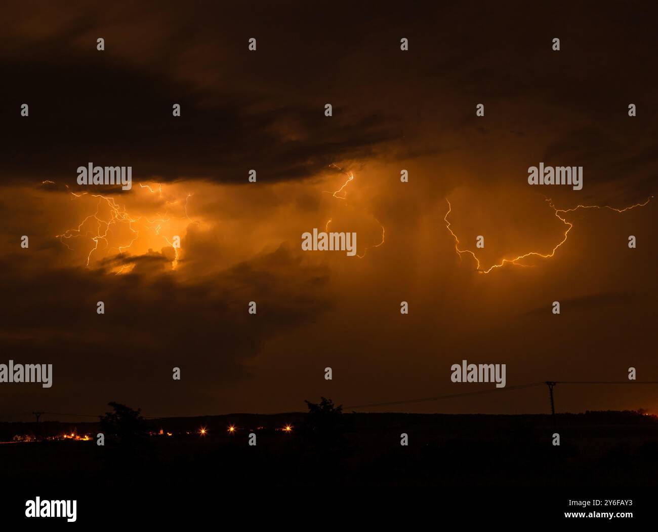 A dramatic night sky illuminated by lightning with dark clouds and ...