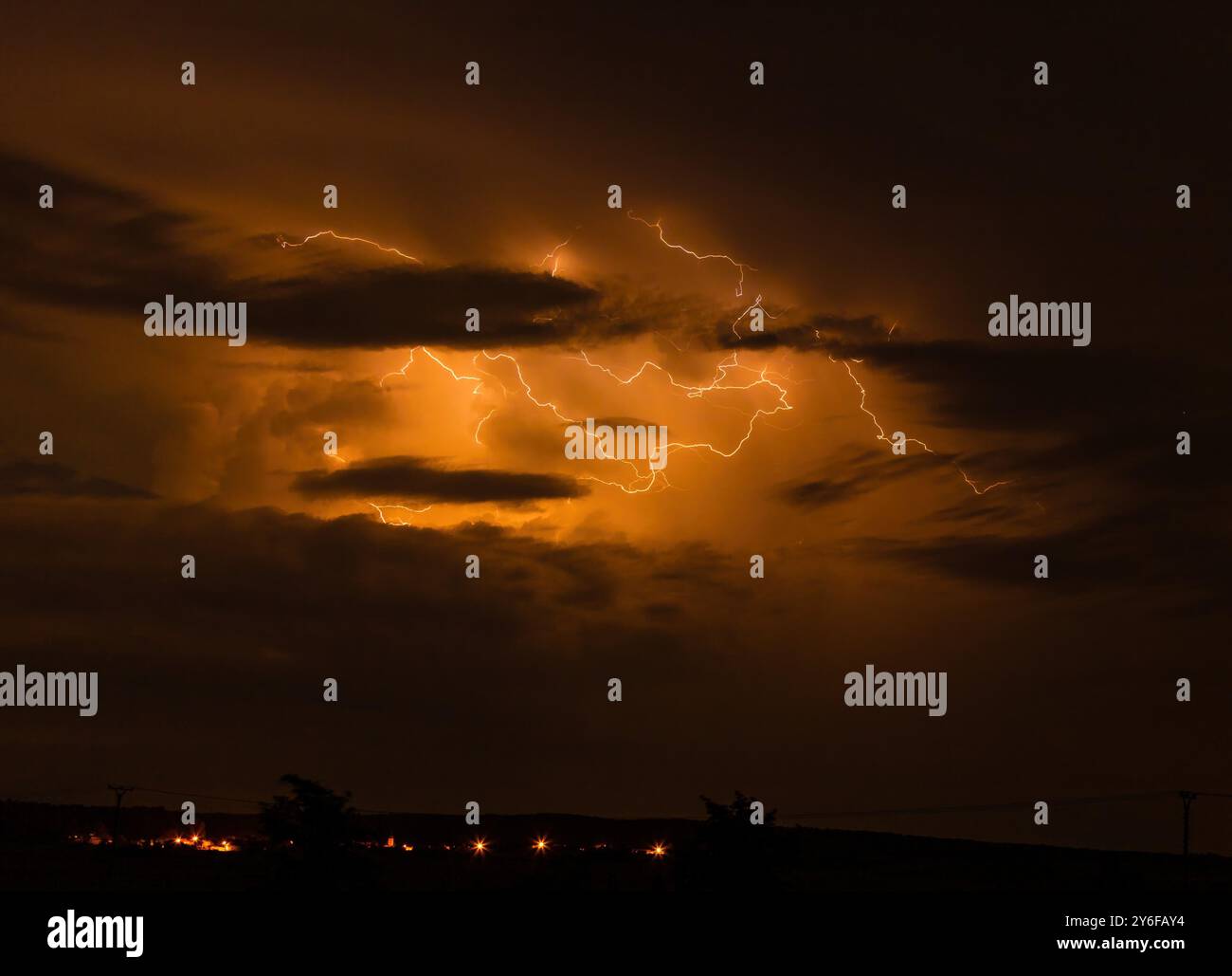 A dramatic night sky illuminated by lightning bolts during a ...