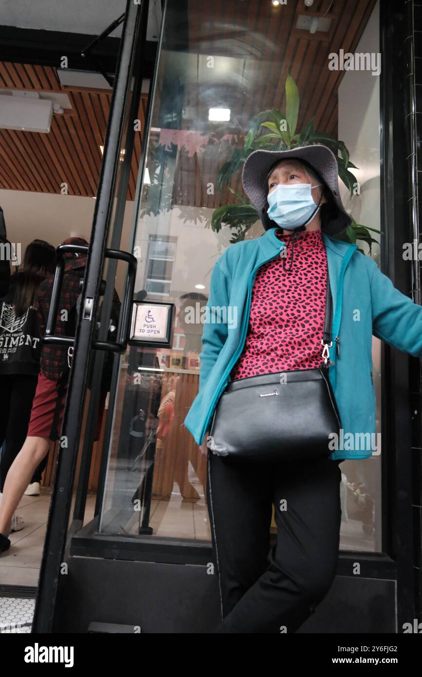 San Francisco, USA, Sept 2024 - A Lady in Chinatown with a Covid face mask Stock Photo