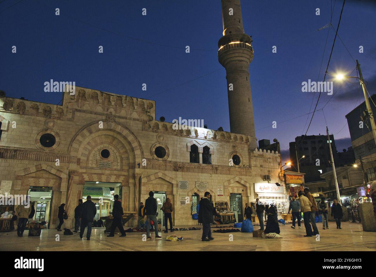 Amman, Jordan, March 2020: Night view of people gathering around in front of Grand Husseini Mosque mosque for prayer, Asia Stock Photo