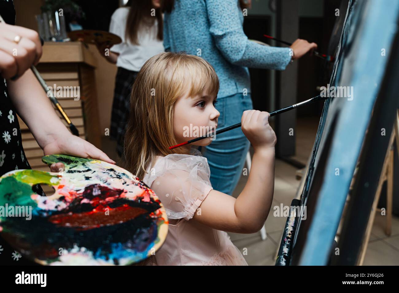 Girl painting on a canvas during a creative art class indoors Stock ...