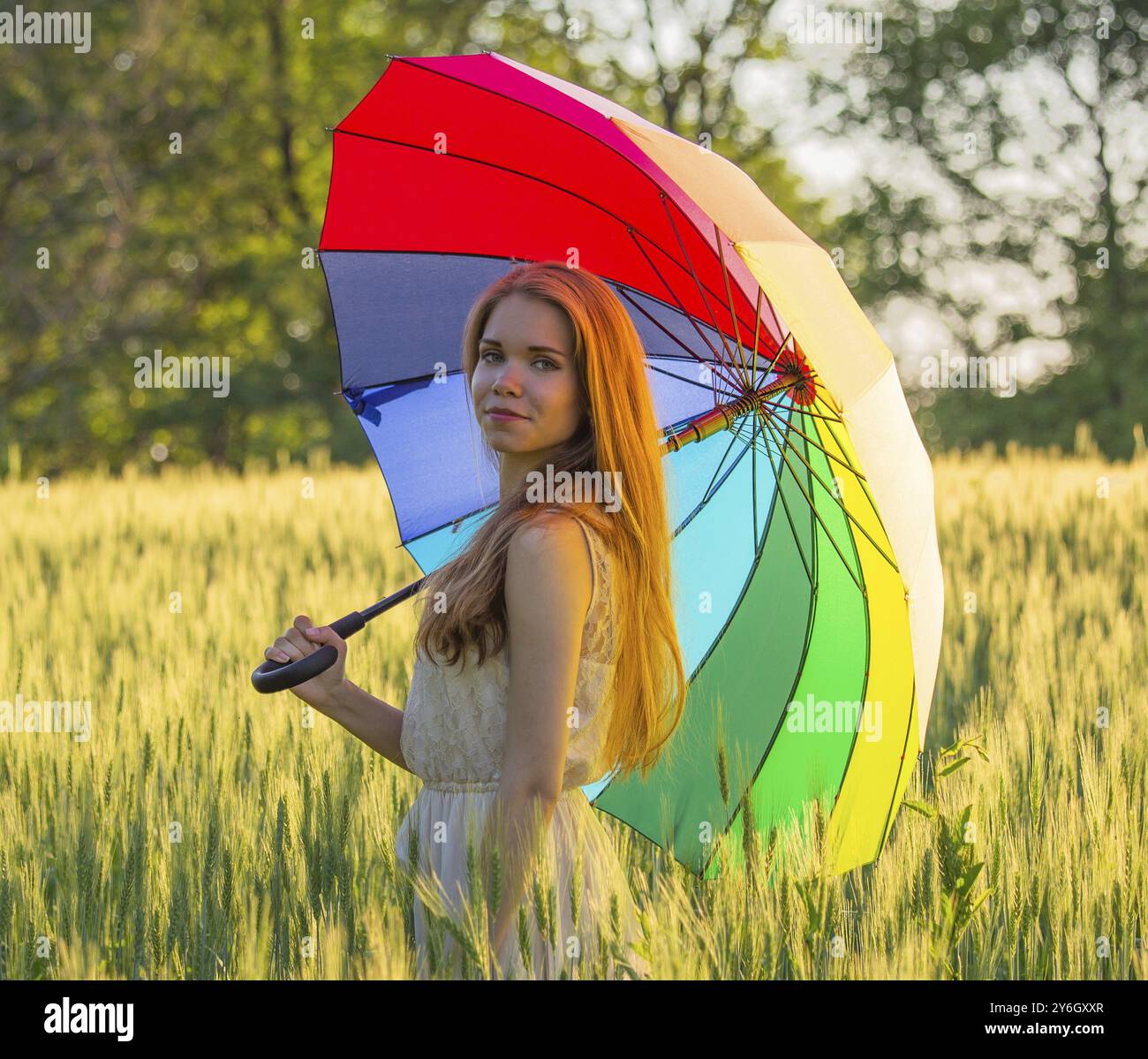 Portrait of a cute girl with a multicolored umbrella Stock Photo - Alamy