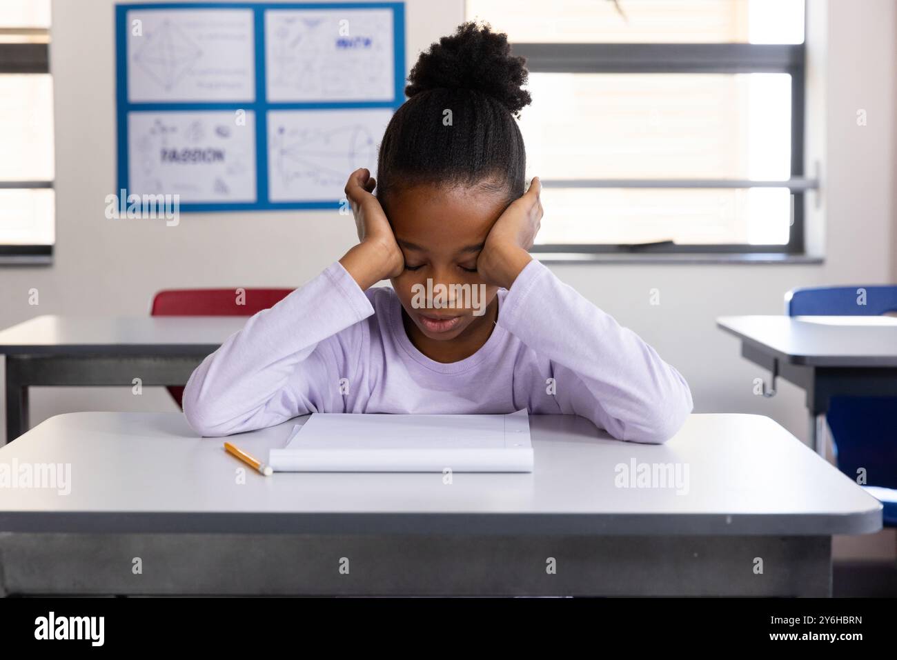In school, african american girl sitting at desk with notebook and ...
