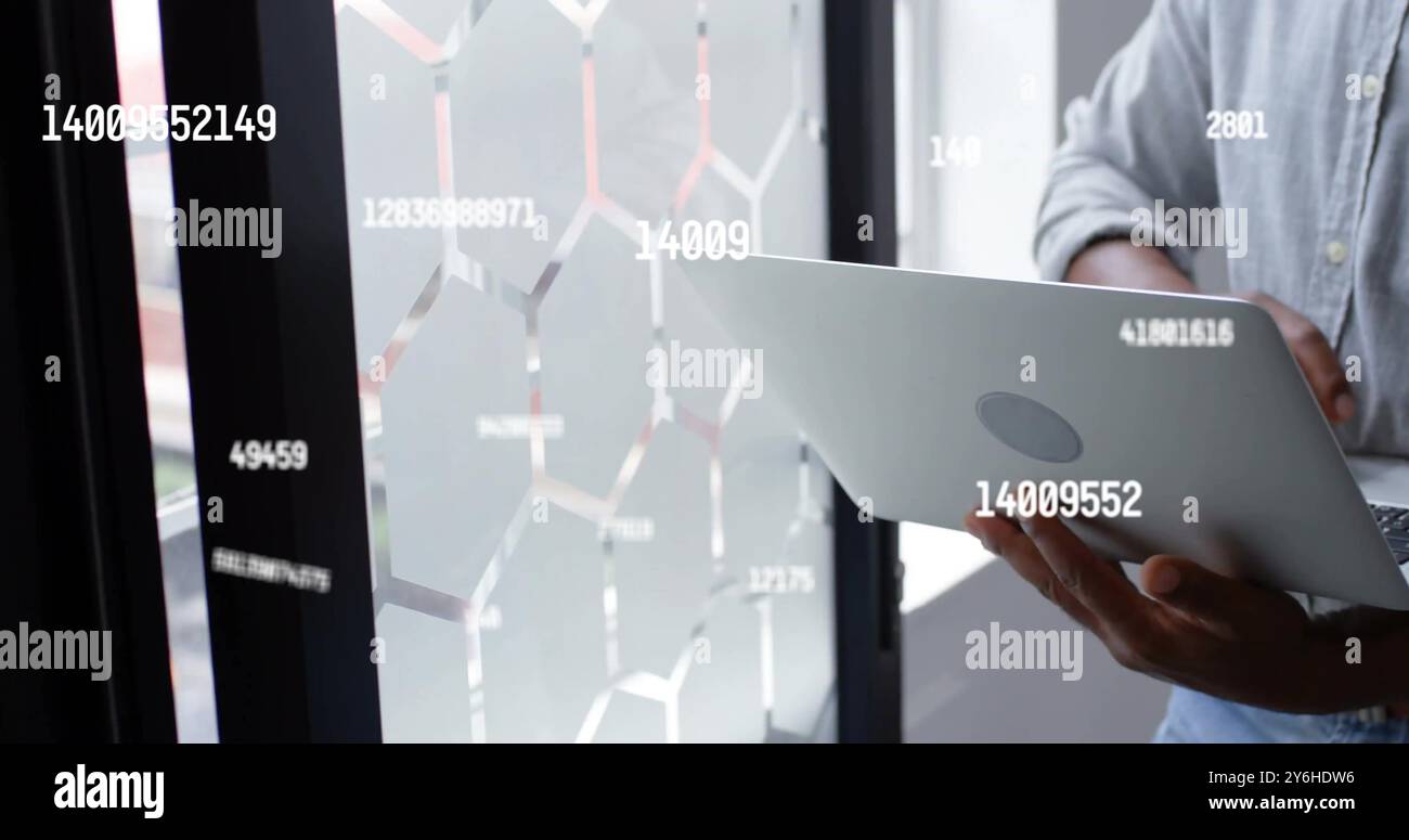 Image of data processing over african american businessman using laptop in office Stock Photo