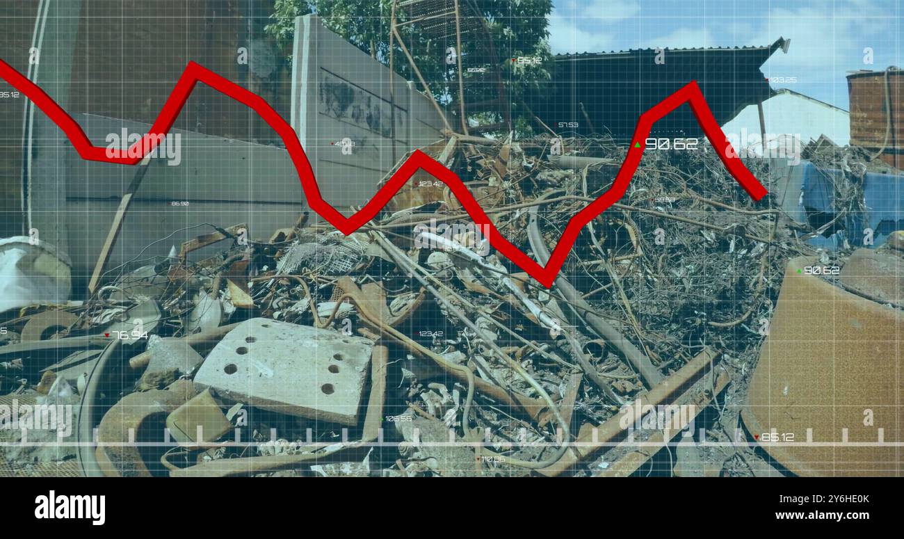 Red declining graph image over industrial scrap yard with rusted metal objects Stock Photo