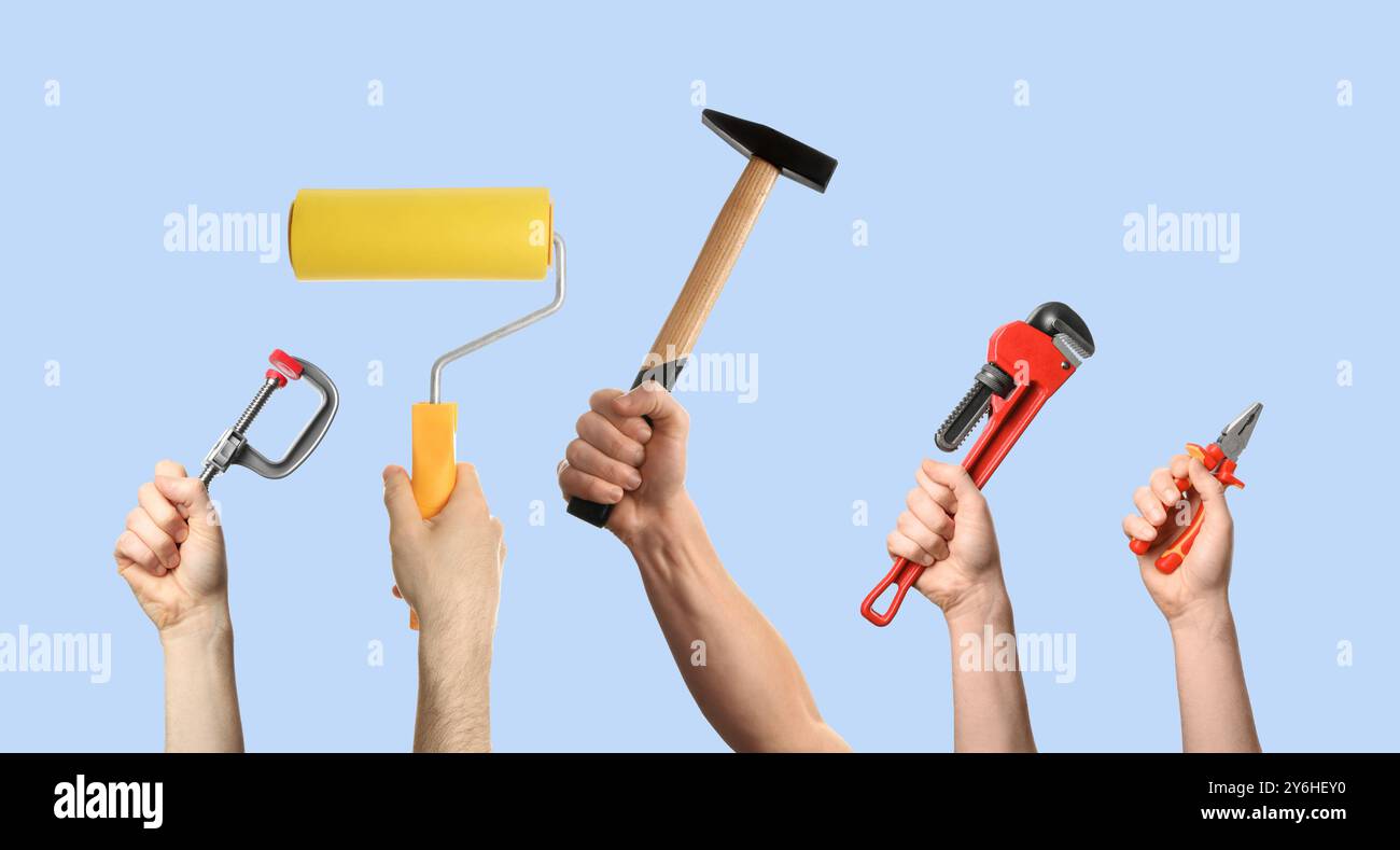 Hands of people with different tools on light blue background Stock Photo