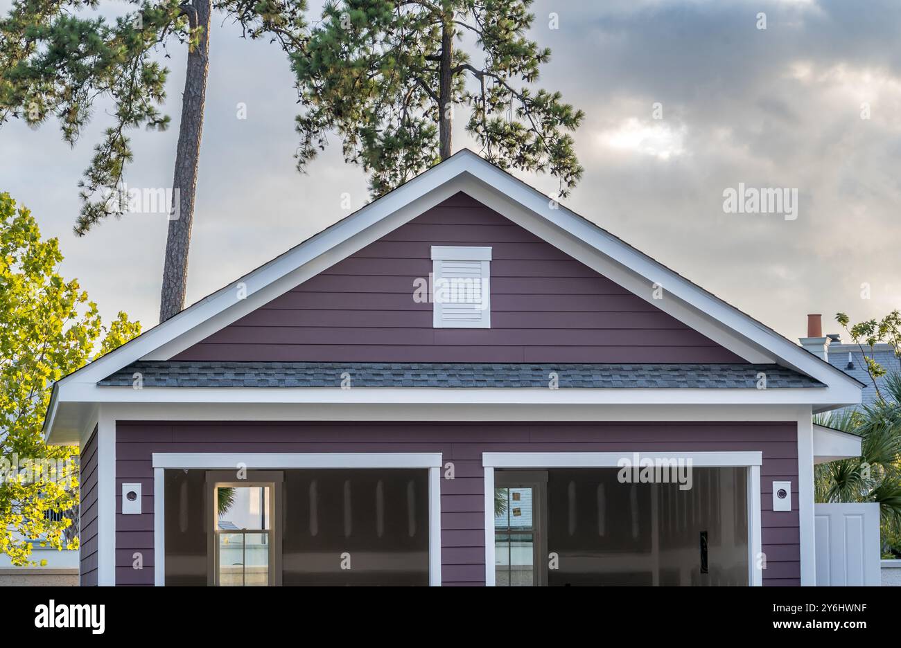 Deep purple gable roof with white frame air vent above an under ...