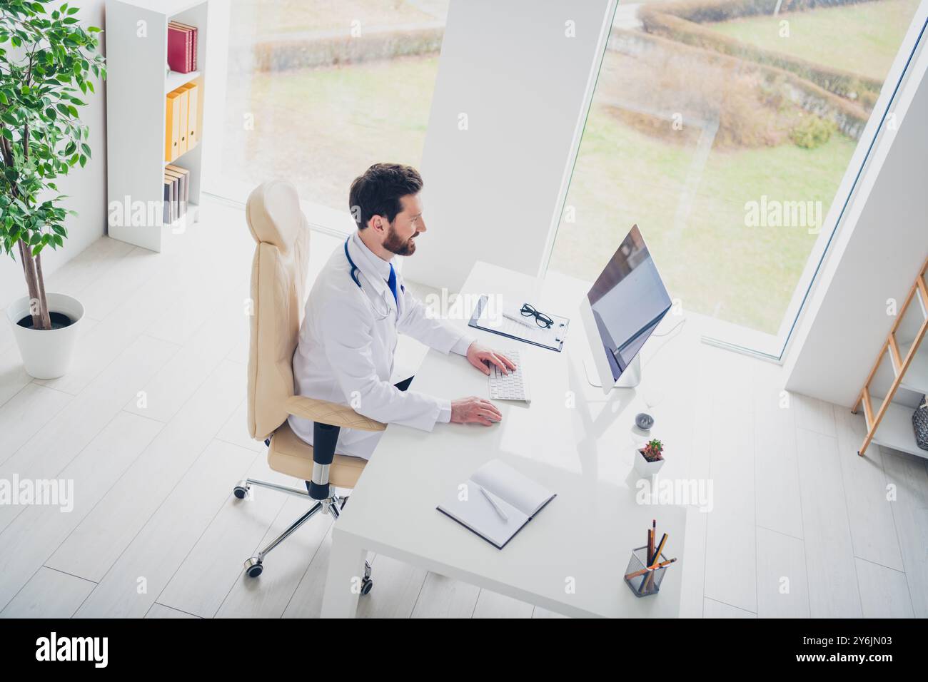 Top view photo of doctor guy sit desk working on computer consultation ...