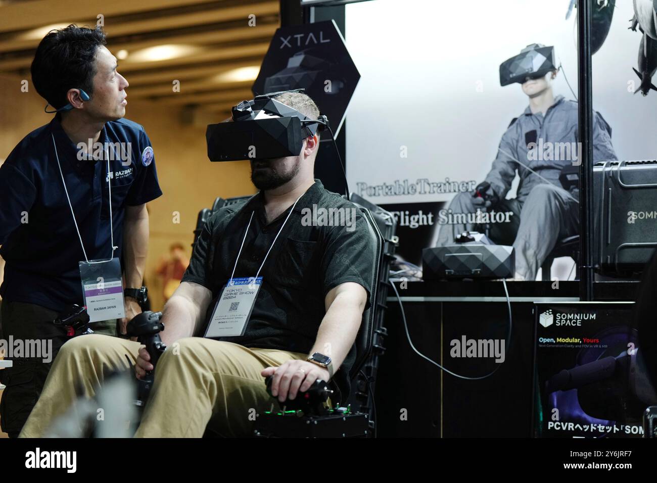 An attendee experiences a flight simulator at the RAZBAM Japan Co 