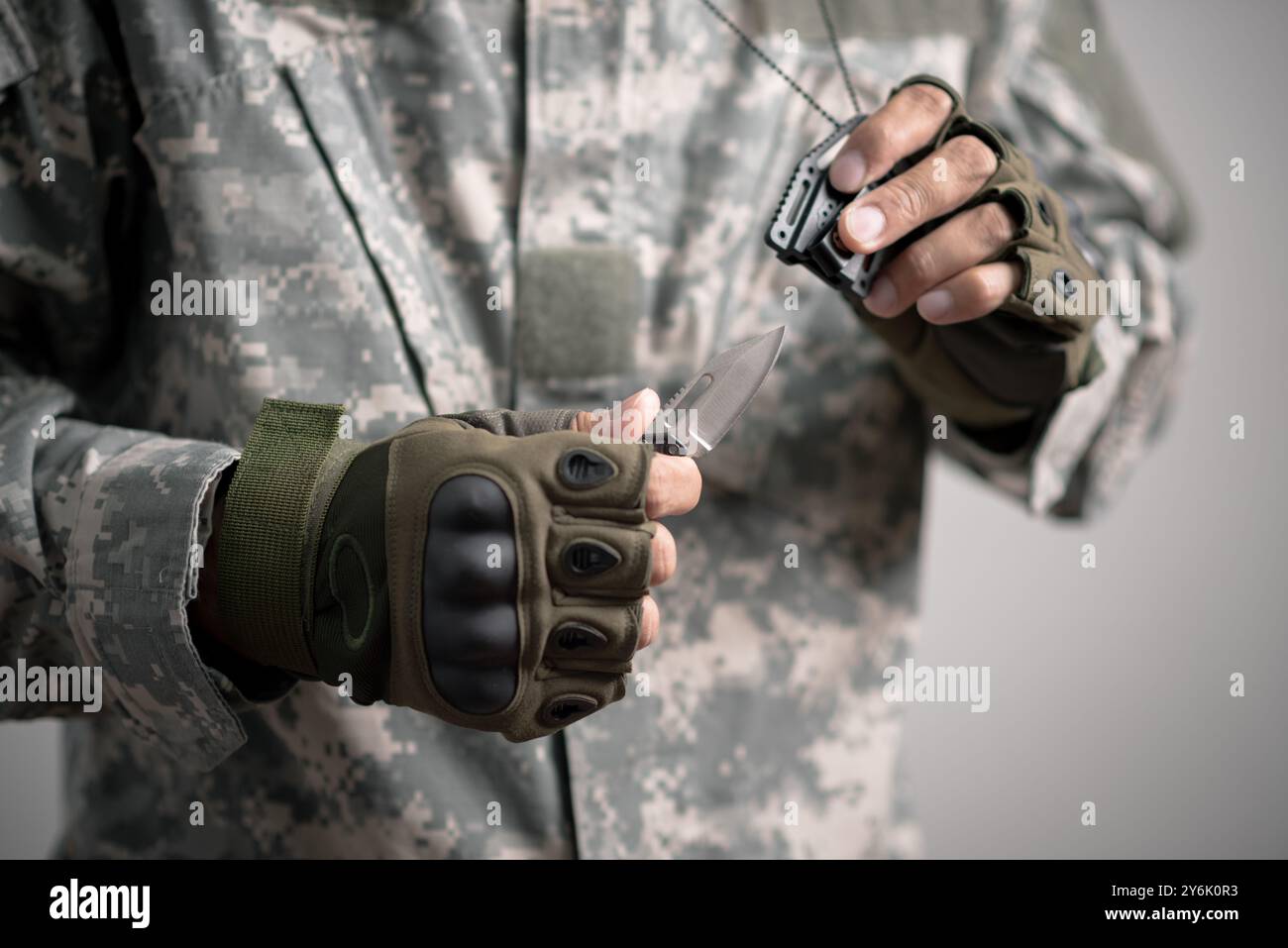 The man wearing tactical gloves using the mini knife. Stock Photo