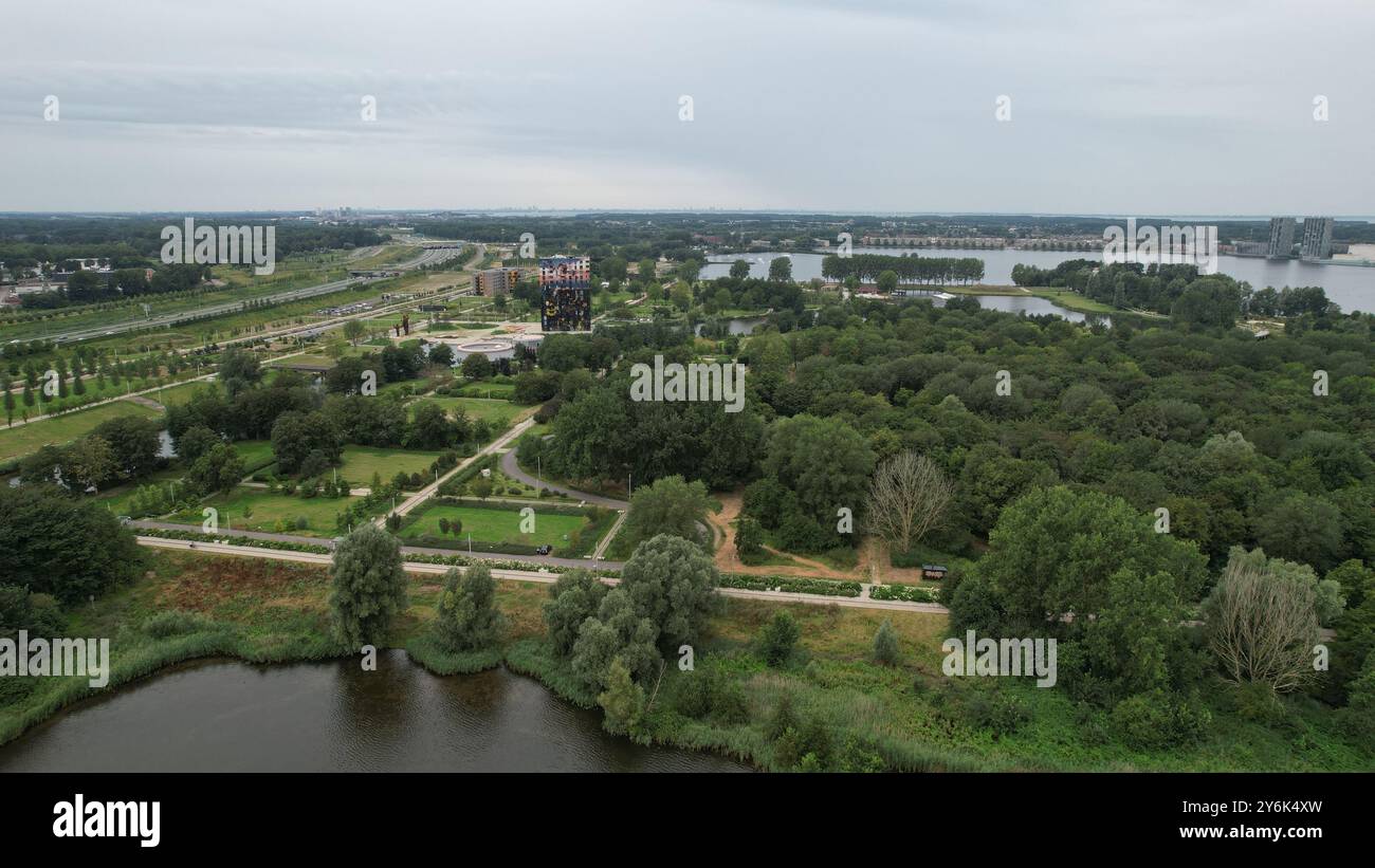 Aerial view of a lush green park with a lake, pathways, and a colorful ...