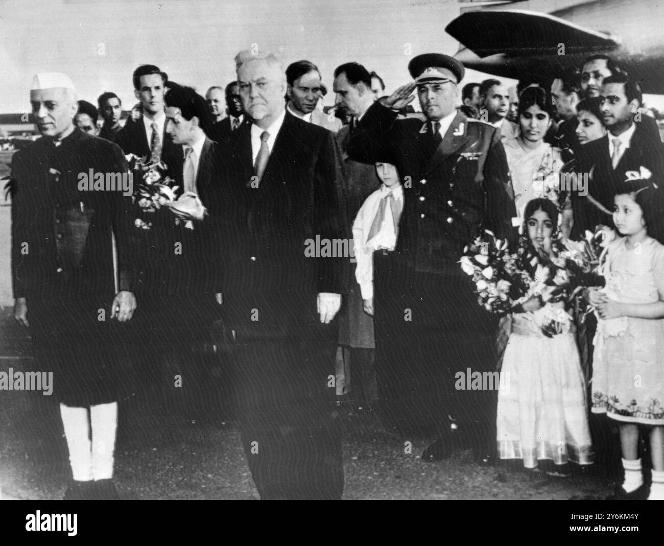 Moscow: Pandit Jawarharlal Nehru (left), Prime Minister of India, and Marshal Nikolai Bulganin (centre), Prime Minister of the Soviet Union, stand to attention at the air port in Moscow, while military bands play the Indian and Soviet national Anthems, after Nehru's arrival from Prague. 8 June 1955 Stock Photo