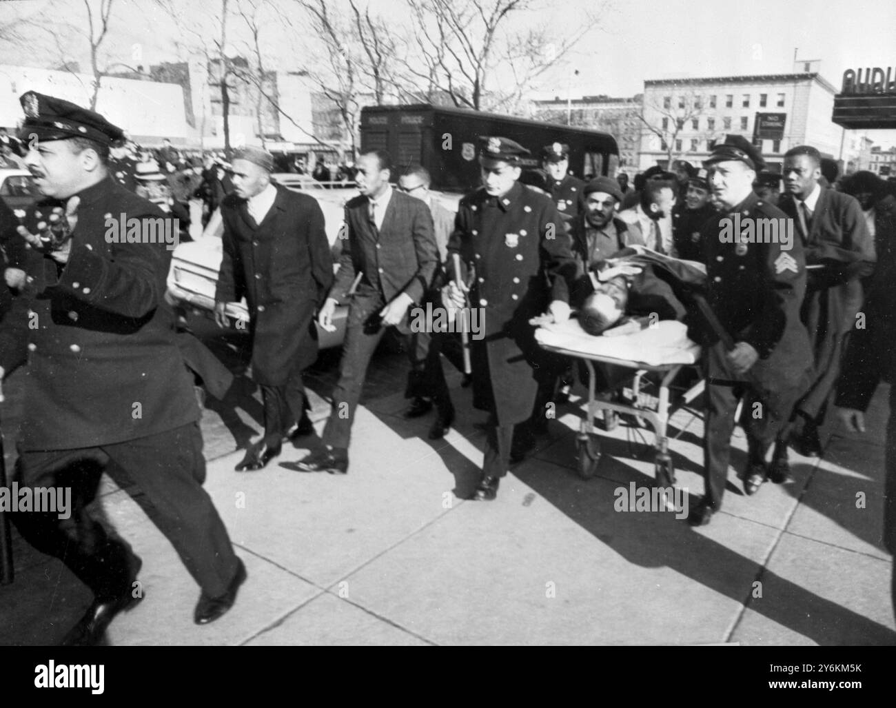 Malcolm X shot dead. New York police carry Malcom X as the fatally shot black Nationalist Leader is taken from the Adobon room here yesterday. Malcom, 29, was felled by a barrage of bullets as he addressed a Harlem Rally of his folowers. His wife, Betty, was among 500 supporters who saw him shot down by a hail of bullets as he began to speak in a ballroom. Two unidentified gunmen were immediately seized.  22nd February 1965. Stock Photo