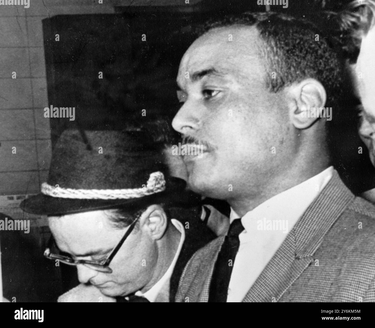 New York: Thomas 15X Johnson, 30 at right, arrives at the Police Station here yesterday after being taken into custody as a suspect in the assassination of Black Nationalist extremist leader Malcolm X. He is the third coloured man to be arrested in connection with the Malcolm X slaying. 4 March 1965 Stock Photo