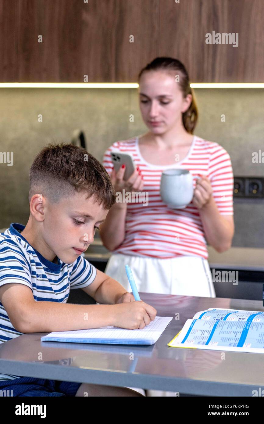 Mother Helping Son With Homework At Table Stock Photo - Alamy