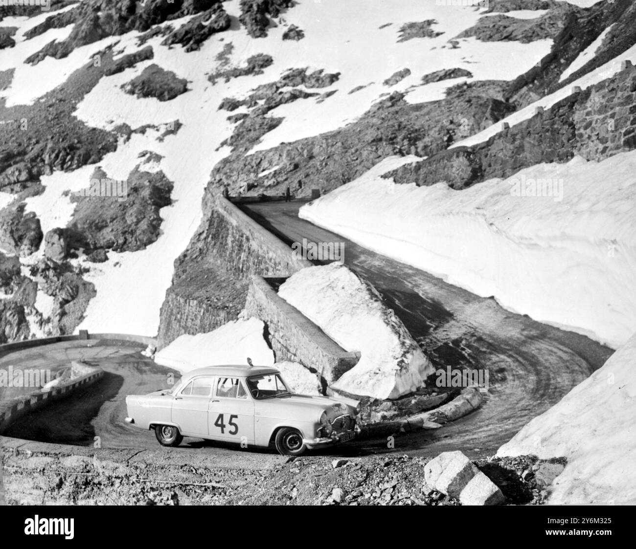 Cannes: The 2,500 mile 20th Alpine Rally ended at Cann and of nine cars awarded the Coupe des Alpes four of them British three were Ford Zephyrs. The same three cars each had a place in their class 2,000 c.c. tourist car class. 1st. Peter Riley and Alick Pitts; 2nd T.C. Harrison had his son John; 3rd Edward Harrison and J.W. Fleetwood. Photo shows: T.C. Cuth Harrison, a Sheffield Motor Dealer, and his son John in the Ford Zephyr at Stelvio Pass during the rally, in which they ere awarded a Coupes des Alpes and also 2nd place in the 2,000 c.c. tourist car class. Edward Harrison T.C.'s other son Stock Photo