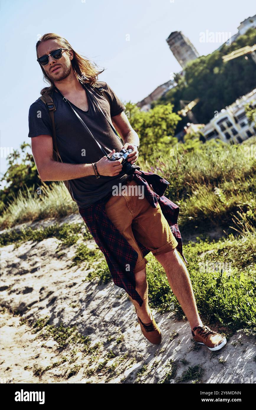 Searching for new direction. Full length of young man in casual clothing going somewhere while walking on the hill outdoors Stock Photo