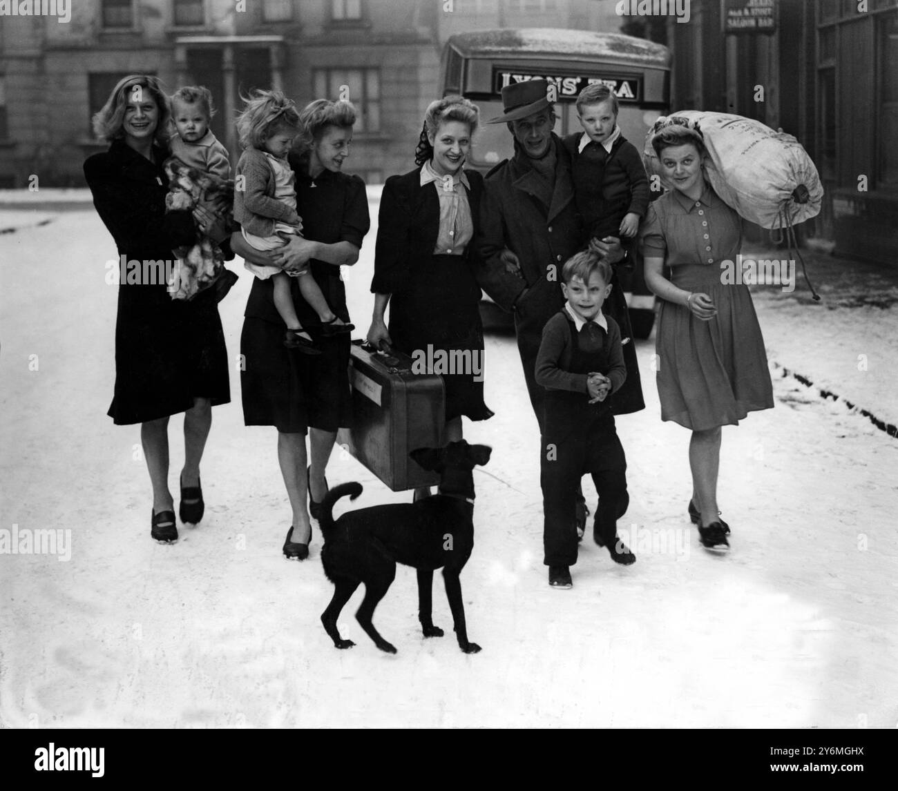 WWII. Bill Martin is home from the jungles of Burma, to be greeted by his family in NW London. His mother carries his kitbag over her shoulder. Stock Photo