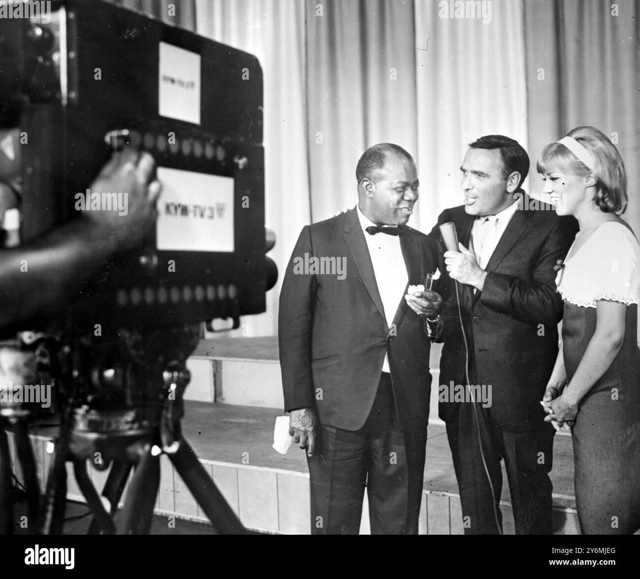 Atlantic City, U.S.A: Louis 'Satchmo' Armstong and a giant cake for his 65th birthday  and he did not resist. He gave a TV interview which his mouth full of icing, on the basis that for once he wouldn't need to blow his own trumpet. Louis has just returned to America after a visit to Europe including a sell out concert in Budapest. 14 July 1965 Stock Photo