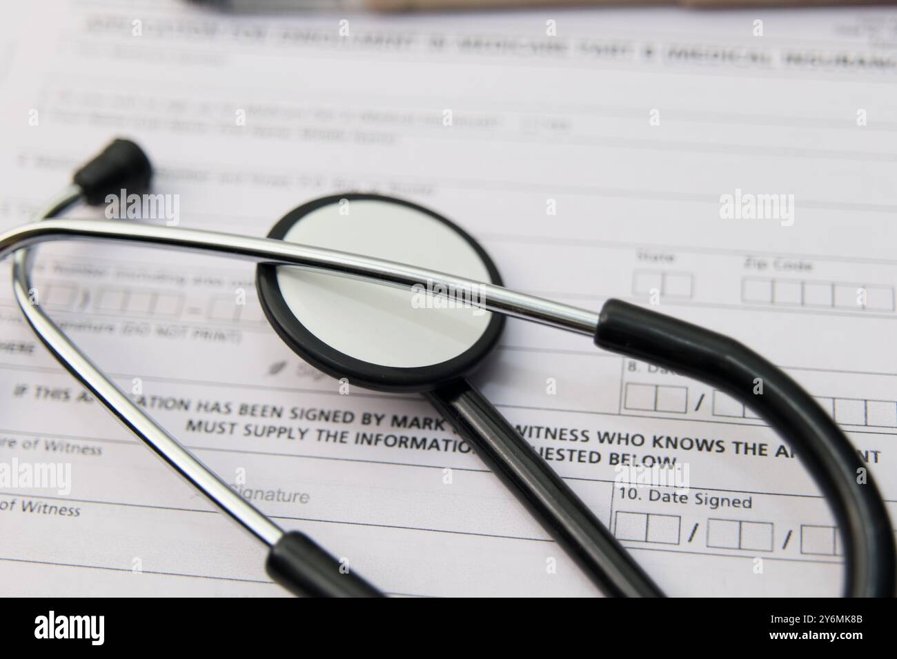 Close up of a stethoscope resting on a blank medical form highlighting