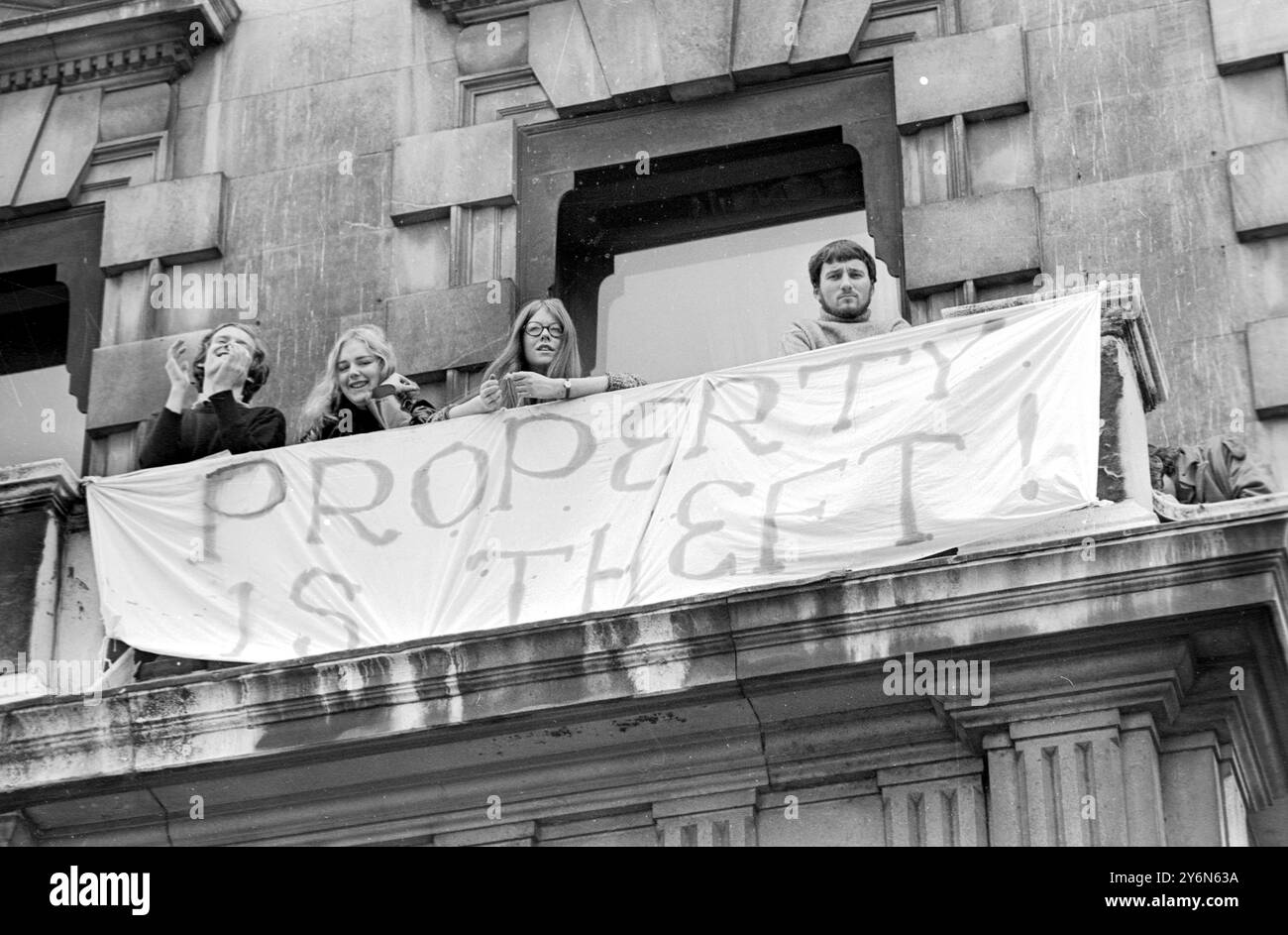 London: Squatters at the empty 60 room mansion a 144, Piccadilly, London, this morning. Ironically, adorning the wall of the building is a poster with the message, 'London Policemen are Wonderful.' The squatters took over the building earlier this week, and by last night, it was reported that 350 persons had moved into the building, which is owned by the Amalgamated West End Developments and Property Trust Ltd.   Yesterday, an ultimatum was given to the squatters in the form of a high court order requiring them to leave the premises by 1600 hours tomorrow.  Hippies negotiating with their neigh Stock Photo