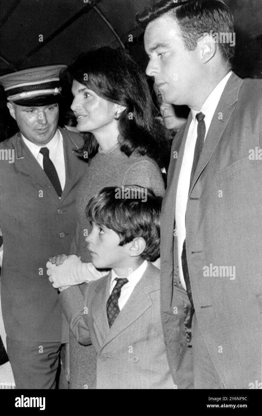 New York: Mrs Jaqueline Kennedy, widow of the late United States President, and her children John Jr., 8,  and Caroline, 10, are guarded by secret service men yesterday as they leave their apartment here for an unknown destination. A short time earlier, Mrs Kennedy's engagement to Greek shipping magnate Aristotle S. Onassis was announced. The wedding is expected to take place next week on the Island of Scorpios in Indian Sea. 18 October 1968 Stock Photo