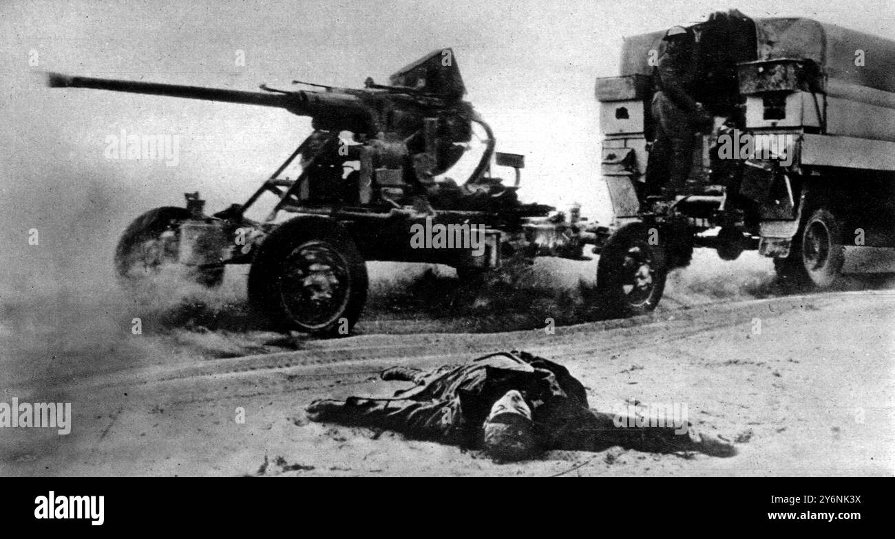 In their headlong retreat, the Germans had no time to bury their dead, who littered the roadside as our army swept on. One of our Bofors A-A guns is being hurried forward towards the Libyan frontier. November 1942  ©2004 Topfoto Stock Photo