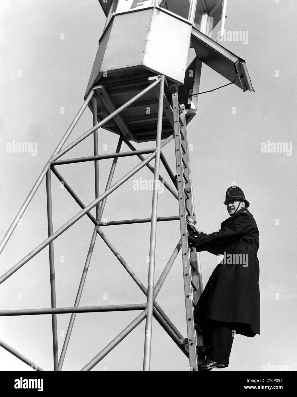 When farmers come into Maidstone on market days the parking problem is solved by directing the cars from a very tall tower in the centre of the market (and car park). A policeman is engaged and from his high perch he can see what space is available and signals to the gatekeepers the number of car spaces in the various lanes.  Built specially for the job, the tower has proved excellent for ensuring the incoming and outgoing raffic flows smoothly.  All who use this car park heartily approve of the parking methods. - Picture shows Reginald Farrow (this is a special duty for him) mounts the ladder Stock Photo