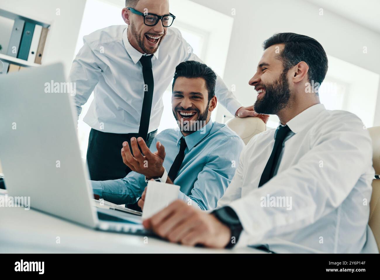 Happy to work together. Group of young modern men in formalwear working ...