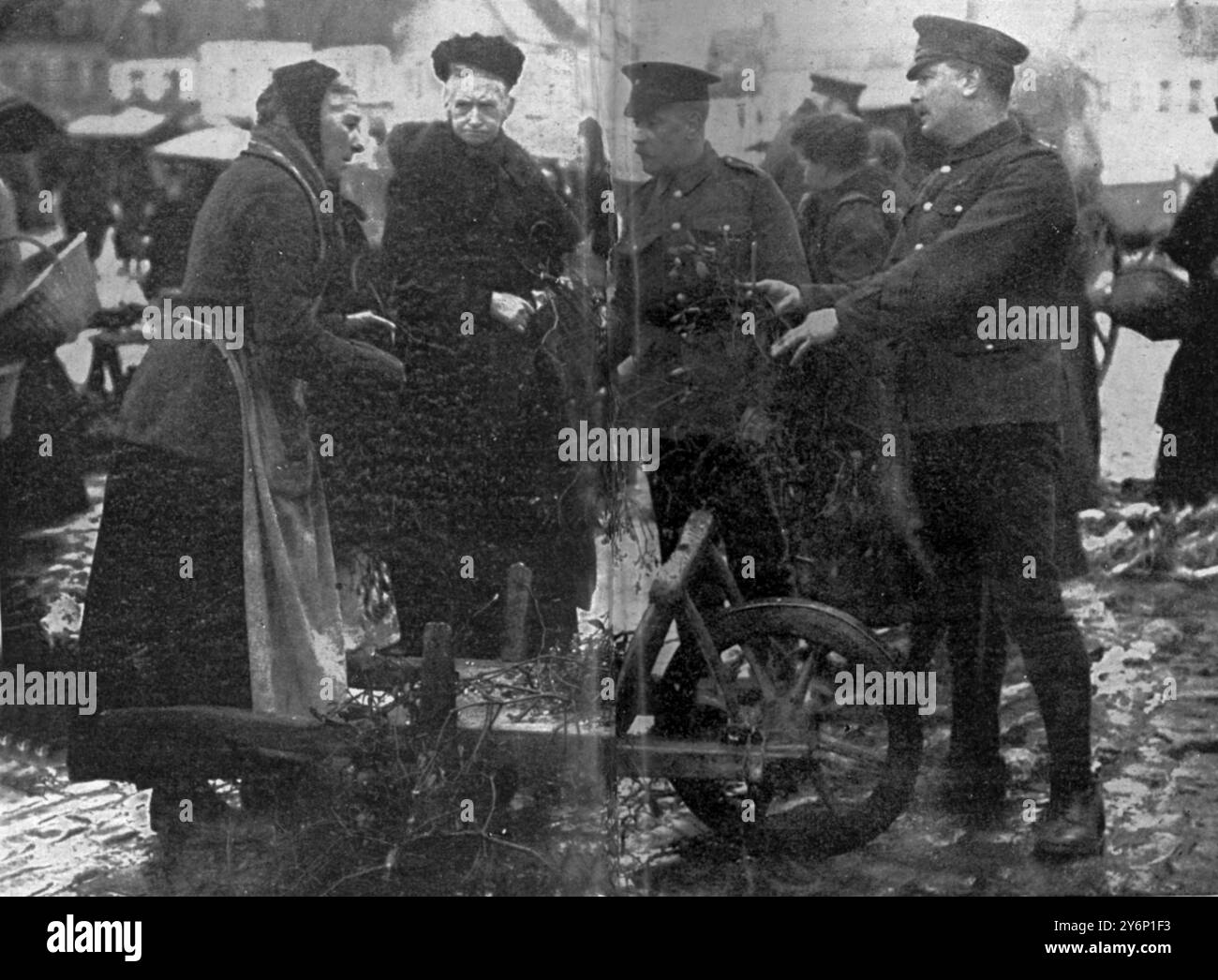 Buying Misletoe British soldier bargaining with a typical old French market woman in a village Stock Photo
