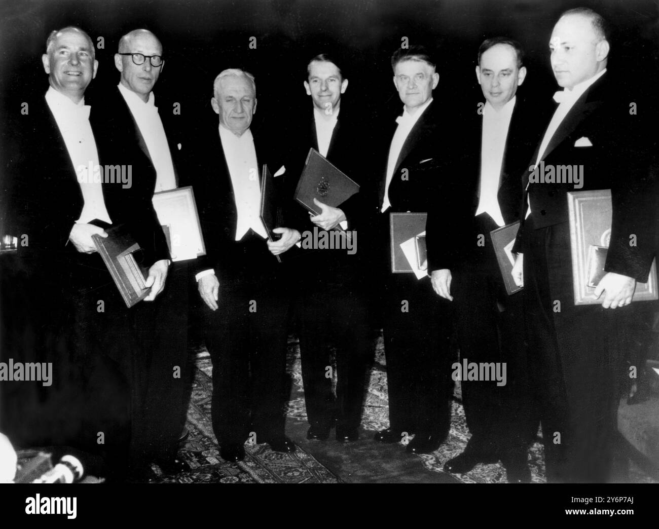 Nobel prizewinners with their awards. Stockholm, Sweden... A group of Nobel Prizewinners with their awards after the presentations by King Gustav Adolf in a ceremony in the Stockholm City Concert Hall.   They are(left to right): Dr. George Beadie , U.S.A., prize for medicine; Professor Edward Tatum , U.S.A., prize for medicine; Igor Tamm , Russia, prize for physics; Dr. Frederick Sanger , Cambridge University, prize for chemistry; Pavel Cherenkov , Russia, prize for physics; Ilya Frank , Russia, prize for physics; and Joshua Lederberg , U.S.A., prize for medicine.  Dec. 10th 1958 Stock Photo