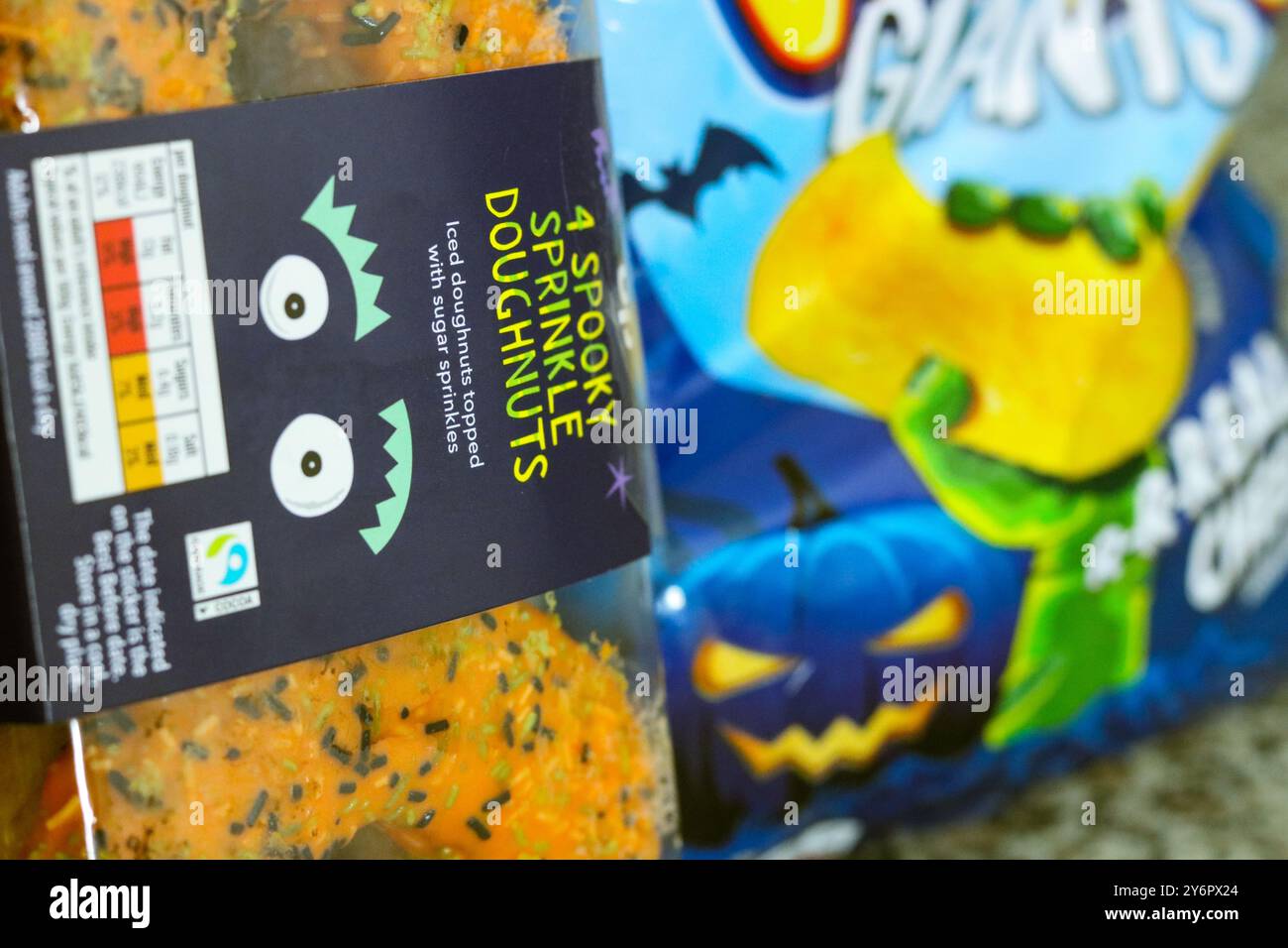 London, England, September 26 2024: Halloween branded food, bag of crisps and donuts in the kitchen close-up Stock Photo