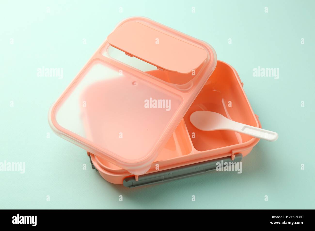 Empty lunch box with spoon on light blue background Stock Photo