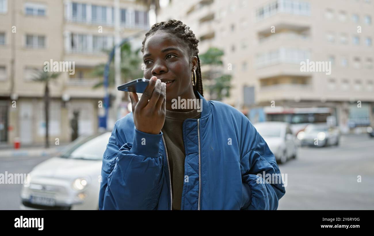 African american woman with braids talking on smartphone on urban ...