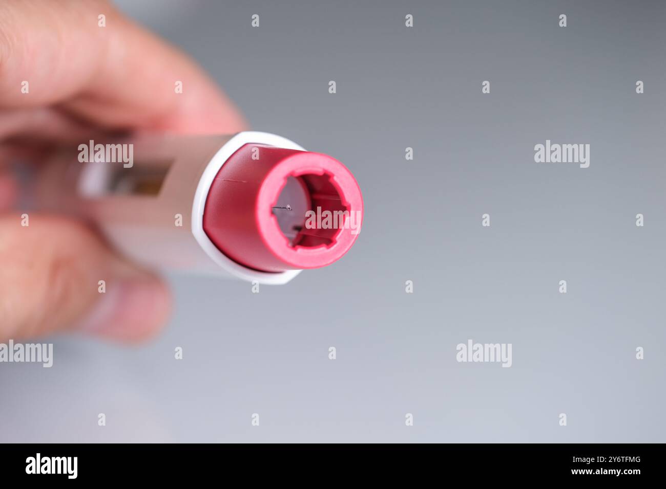 a hand shows a pen injector for biological treatments such as ...