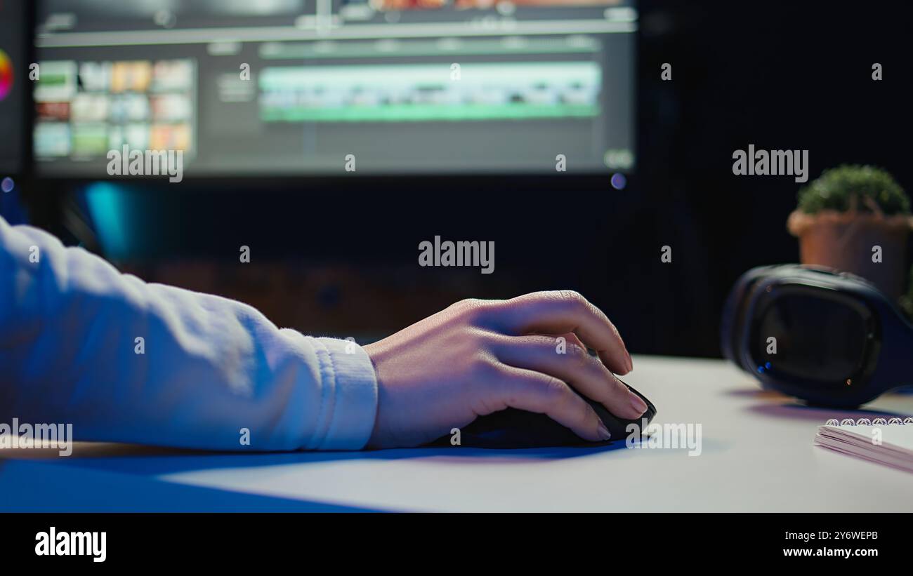 Extreme close up shot of video editor selecting key frames to use while doing video montage, working from home on computer. Woman using mouse to edit movie project footage in studio, camera B Stock Photo
