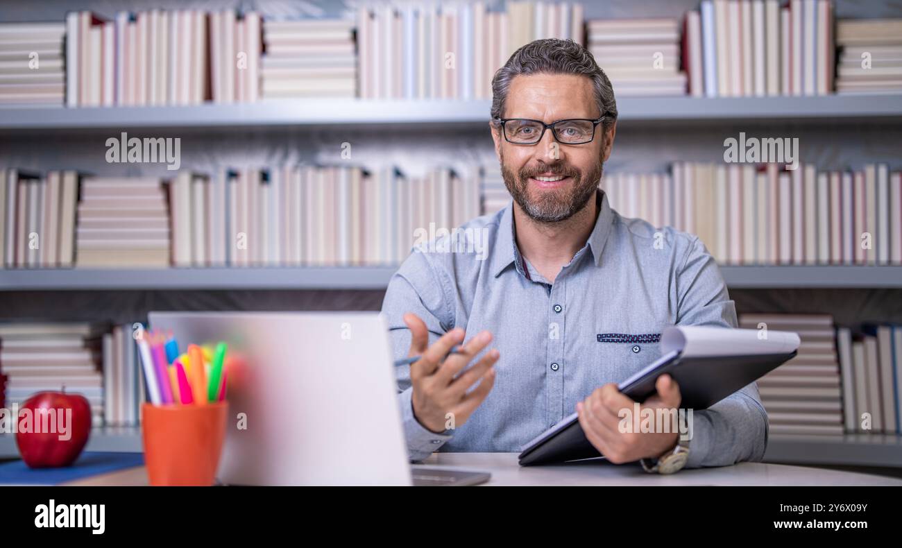 Tutor Man Teacher in classroom. school tutor with book in classroom. Man on ...