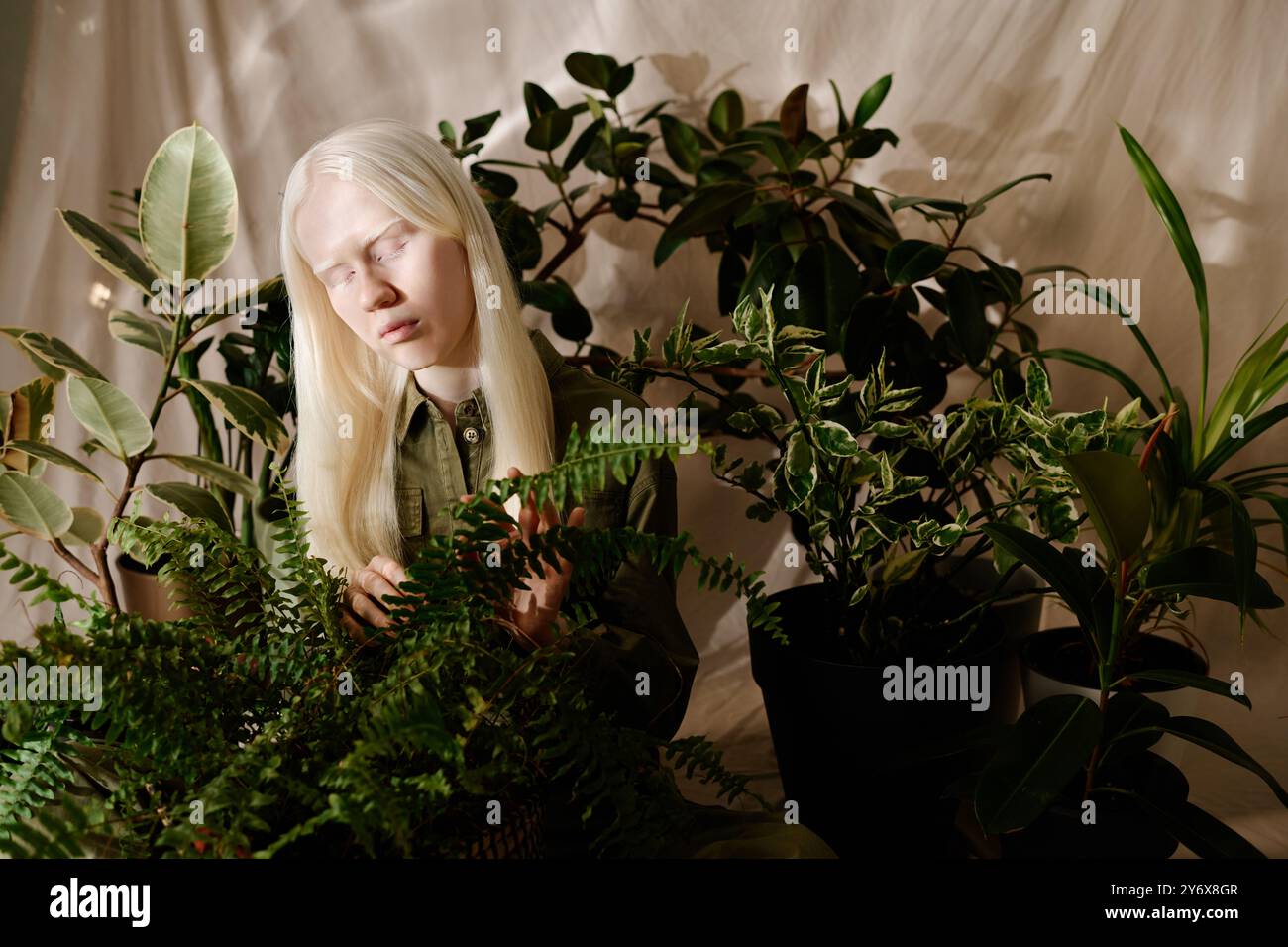 Young Woman With Houseplants Studio Portrait Stock Photo