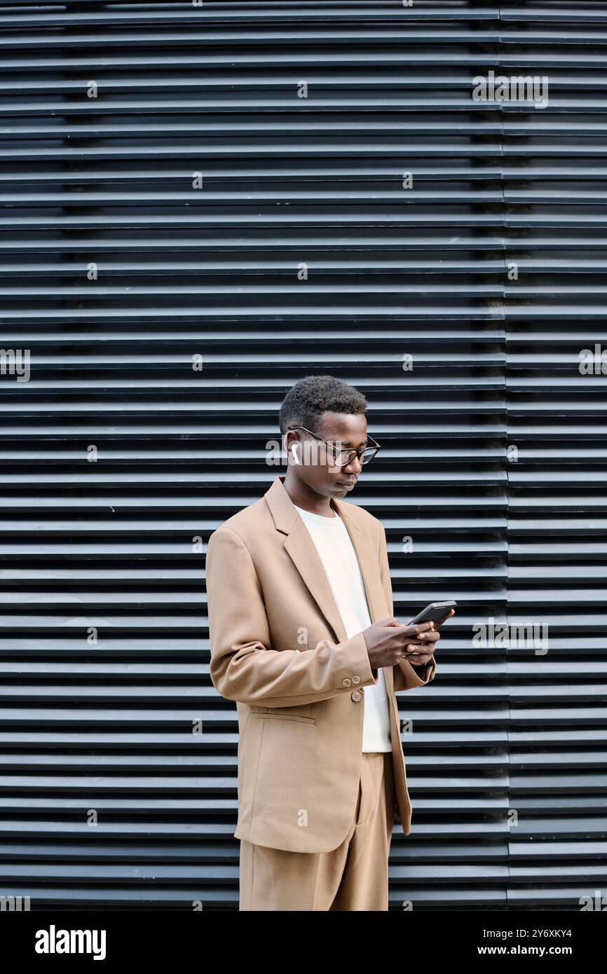 Young Black Man Using Smartphone Outdoors Stock Photo