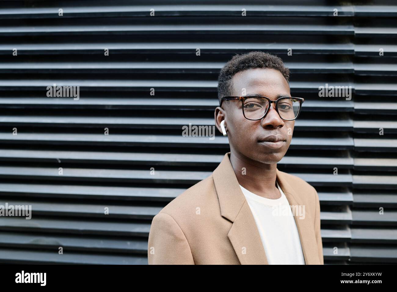 Young Man In Eyeglasses Standing Outdoors Stock Photo