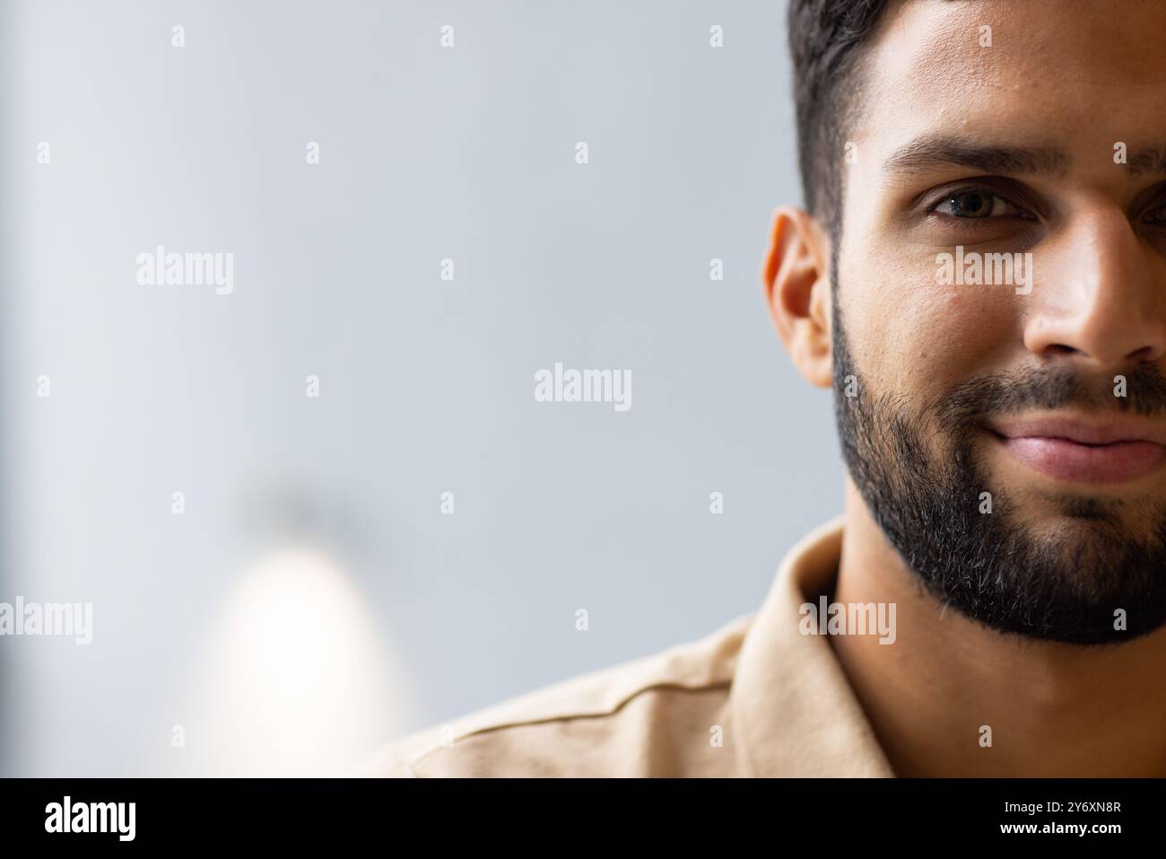 Smiling man with beard looking at camera, close-up portrait in studio, copy space Stock Photo