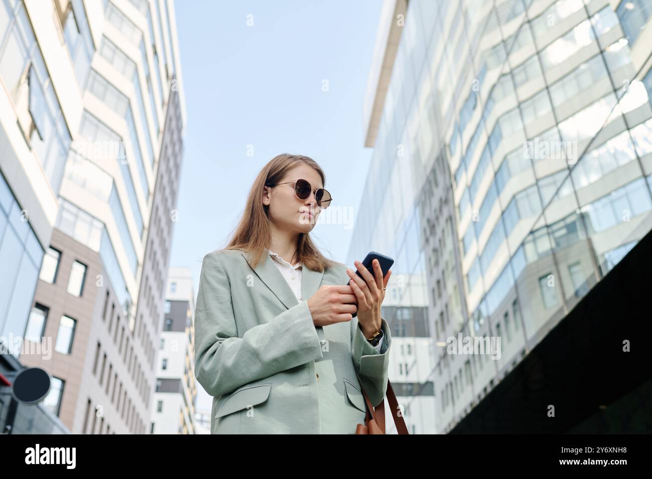 Young Woman In Sunglasses Using Smartphone Stock Photo