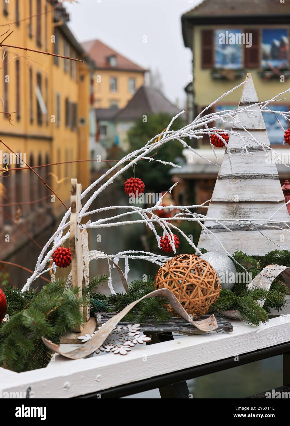 A white Christmas tree with red berries and a white wreath sits on a ...