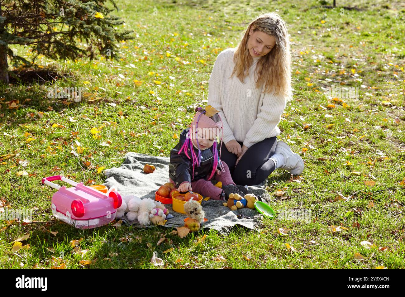 Hello october. Mother and daughter are walking in the autumn city park ...