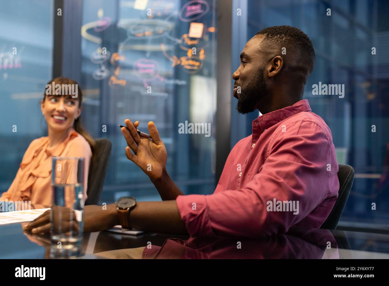 Discussing project ideas, colleagues collaborating in modern office meeting room Stock Photo