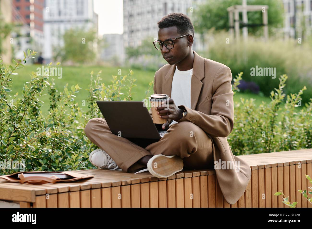 Gen Z Black Guy Working On Laptop During Coffee Break Stock Photo