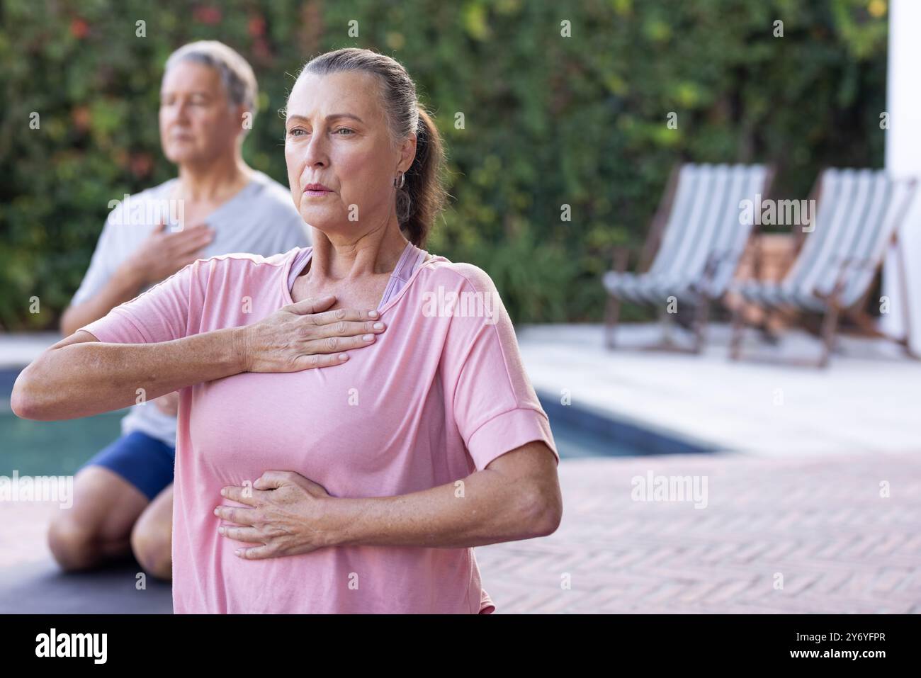 Practicing mindfulness, senior diverse friends doing yoga and breathing exercises outdoors, copy spa Stock Photo