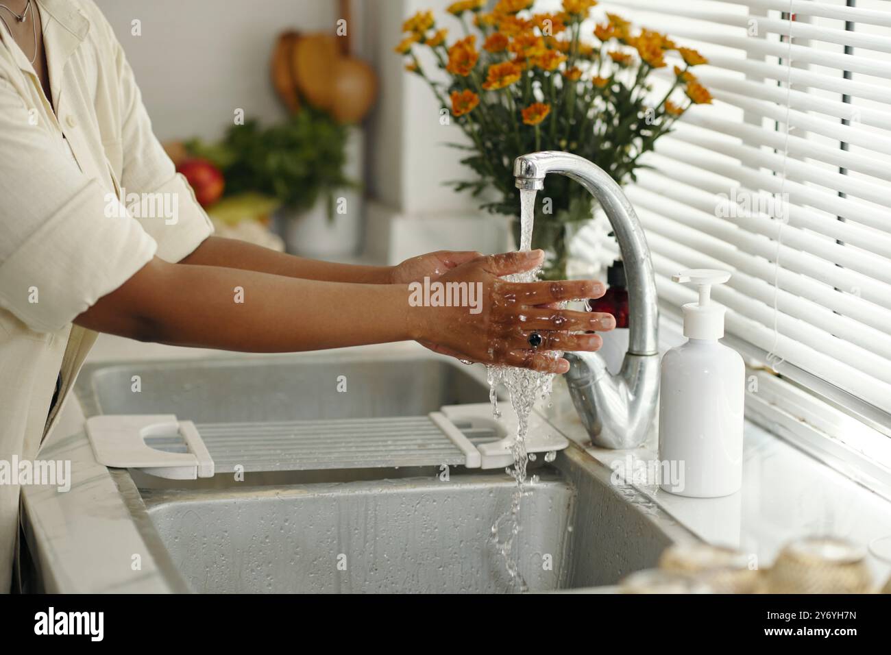 Washing Hands Under Running Water in Kitchen Stock Photo - Alamy