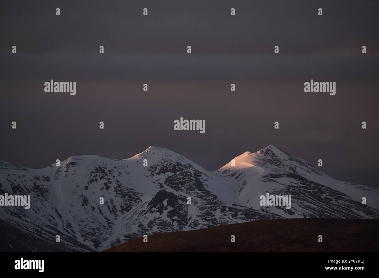 Frozen rocky formation against cloudy dark sky Stock Photo